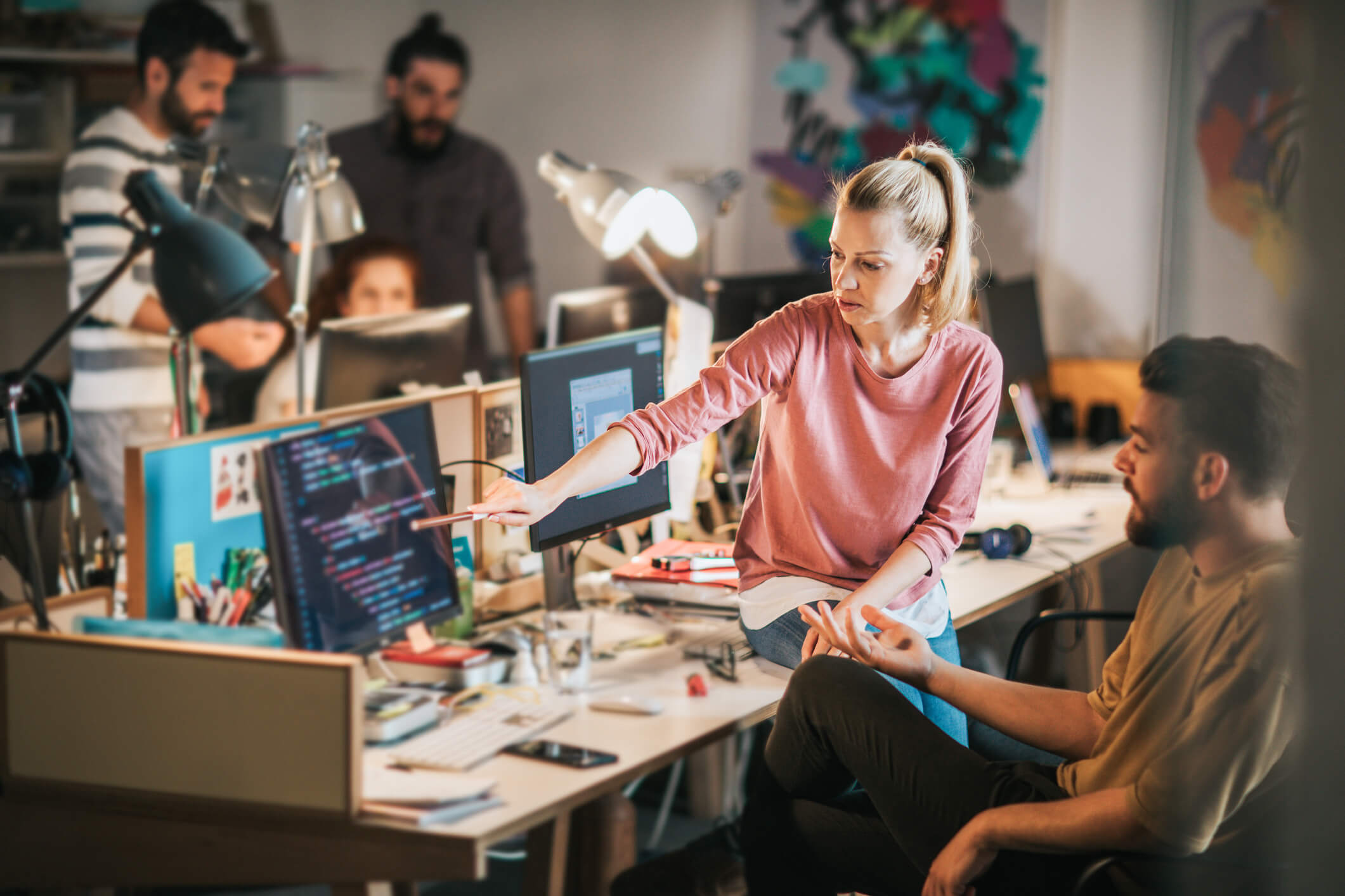 Une femme et un homme assis à un bureau devant un ordinateur dans un bureau